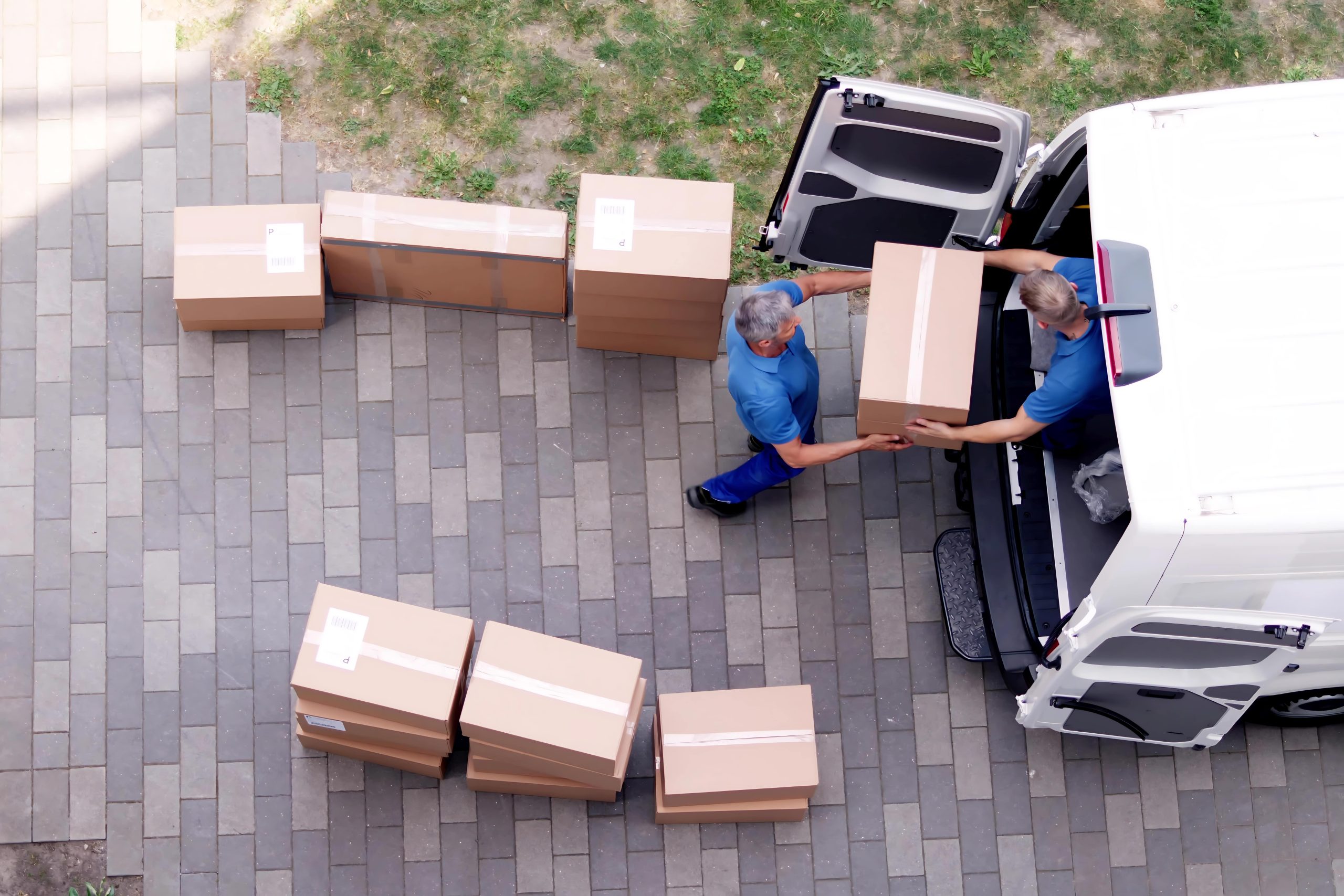 Équipe transportant des cartons entre un véhicule et un bâtiment