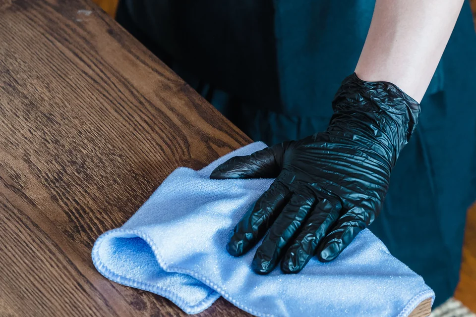 Nettoyage soigneux d’une surface avec des gants et un chiffon microfibre