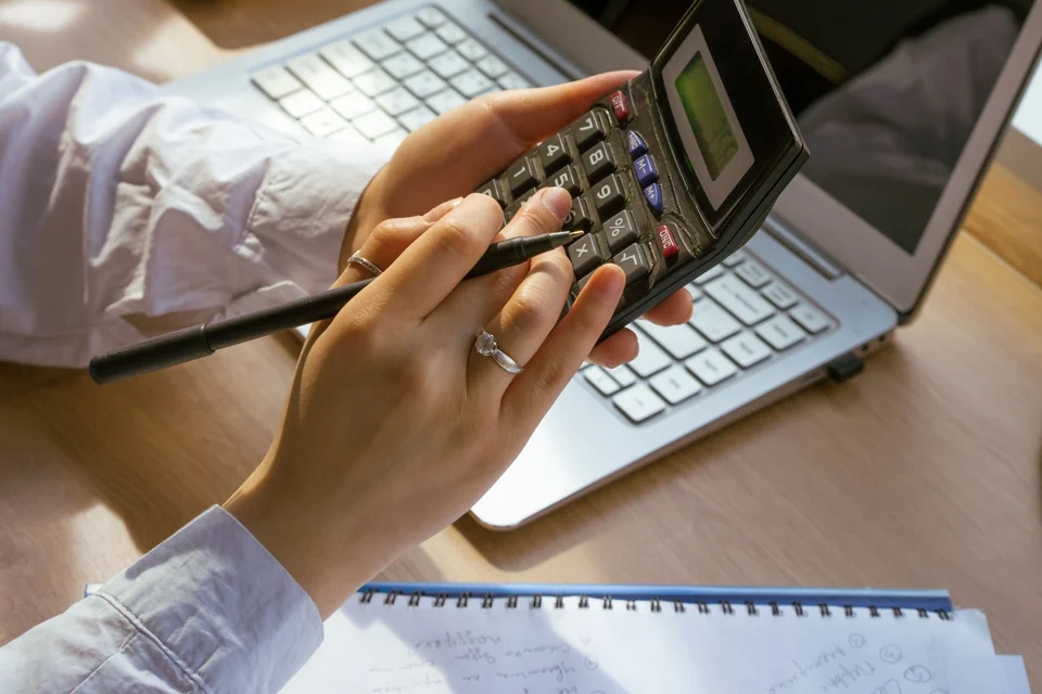 Calcul d’un devis à l’aide d’une calculatrice, d’un ordinateur et de notes.